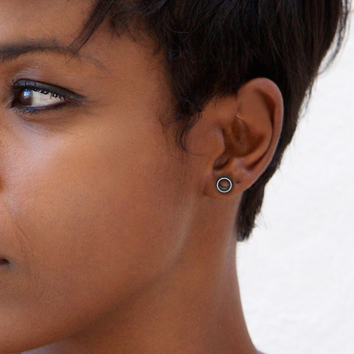 Tunelis melnā krāsā ar baltu gredzenu izgatavotu no kaula